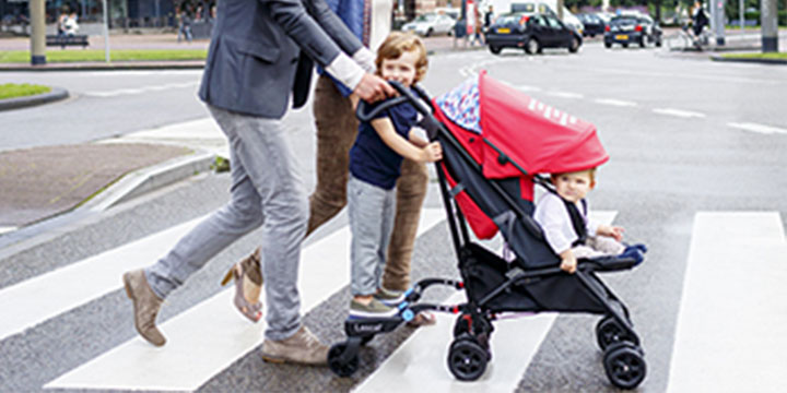 family crossing the street with toddler on Lascal Buggyboard