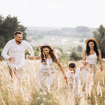 family of four running through a field
