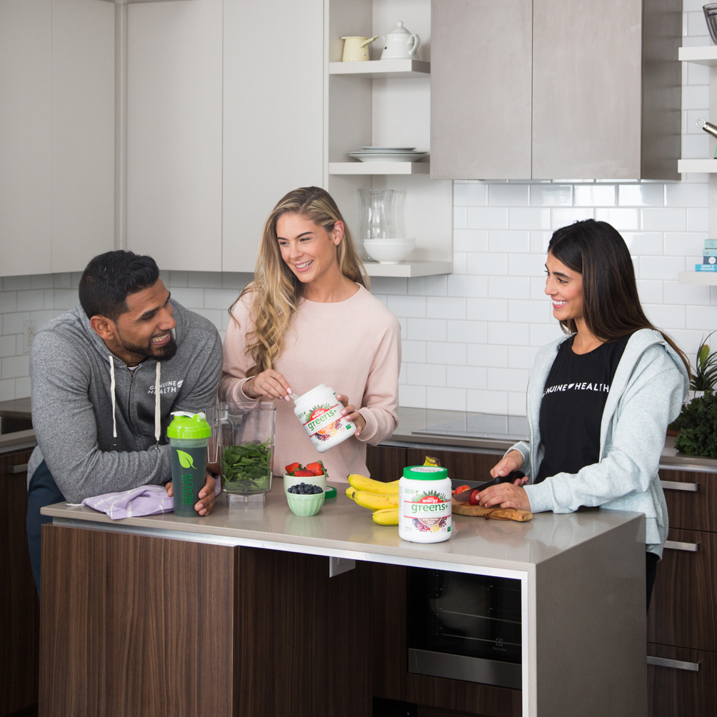 three people in kitchen with Genuine Health products on counter