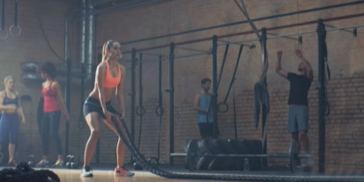 woman working out in the gym with people in the background