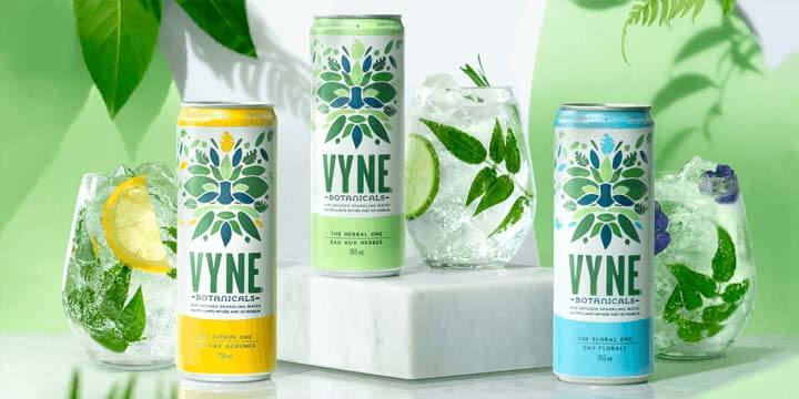 three cans of vyne drinks with plants in background