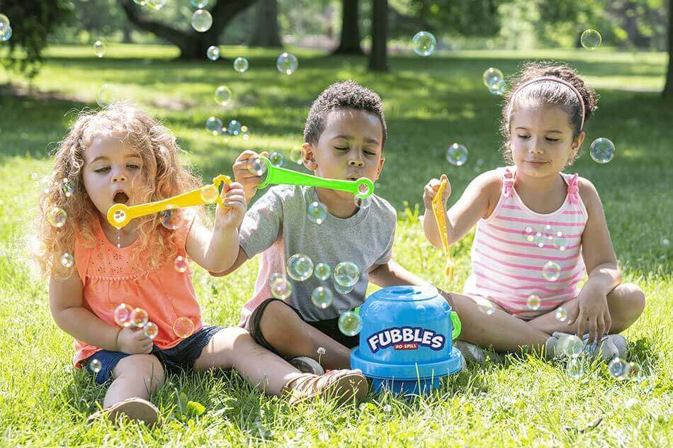 3 kids blowing bubbles from fubbles brand