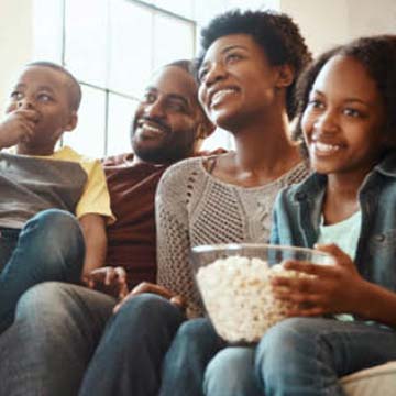 family sitting around eating bowl of popcorn