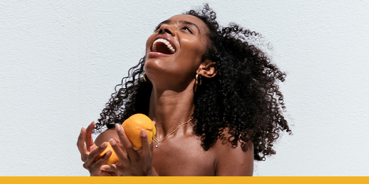 woman smiling holding oranges