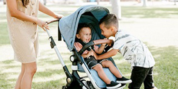 woman pushing stroller with 2 kids