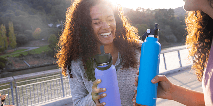 2 women holding hydro flask bottles